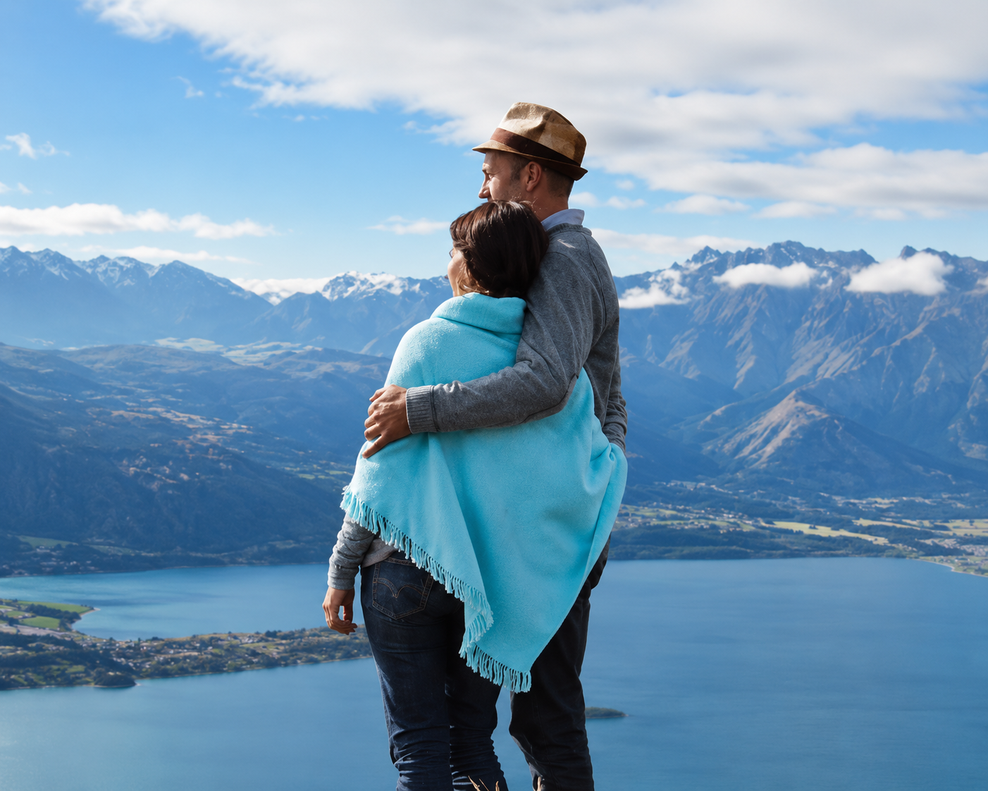 Couple embracing while looking out over a mountain lake